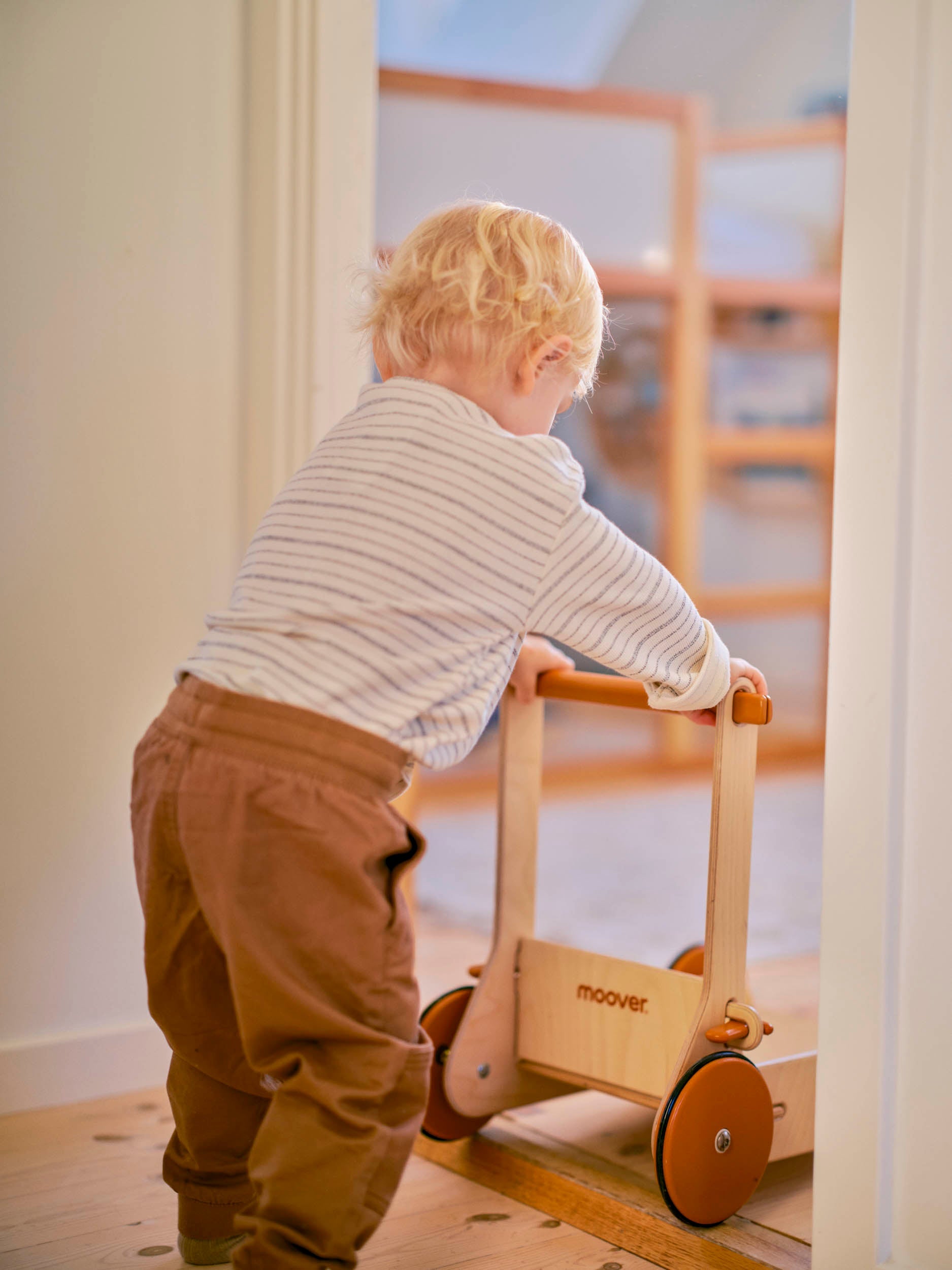 Baby walking with a wooden baby walker from moovertoys